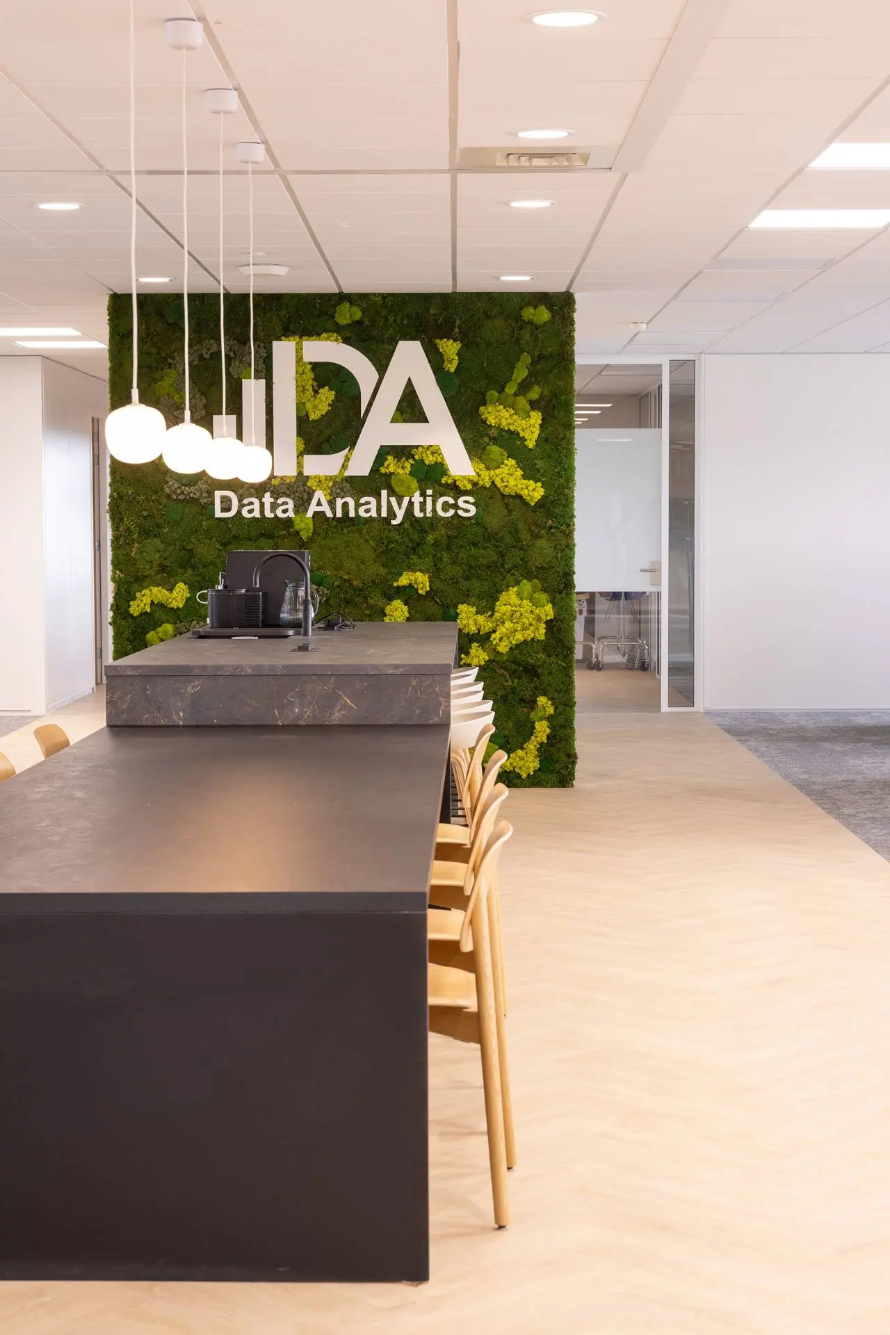 Kantoor van Data Analytics met mosmuur en logo